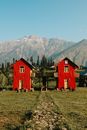Red Wooden House on Green Grass Field Near Mountain
