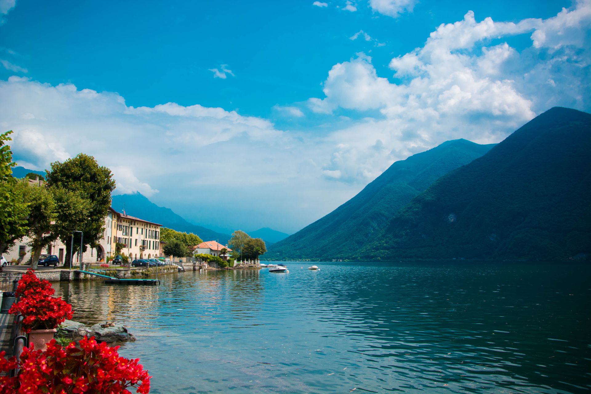 Charming town of Cima by Lake Como with vibrant blooms and mountain backdrop.