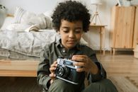 Boy in Gray and Black Jacket Holding Camera