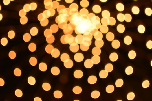 Abstract image of defocused golden lights with blurred motion, creating a decorative bokeh effect.
