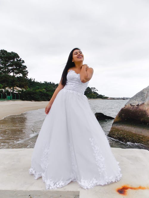 Bride in Wedding Dress Standing on the Beach 