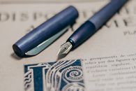 Blue and Silver Click Pen on White Paper