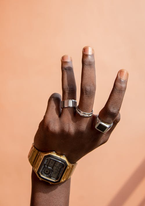 Hand of person with wristwatch and rings