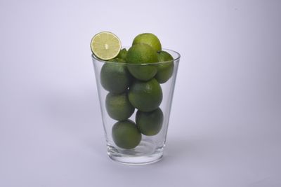 Fresh green limes in a glass on a white surface. Photo by Jacob Moseholt on Pexels.