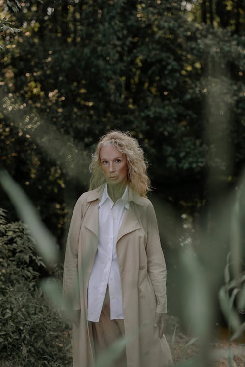 Woman Wearing a Coat Standing Near Plants