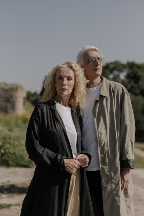Free Elegant senior couple posing outdoors in stylish coats against a natural backdrop. Stock Photo