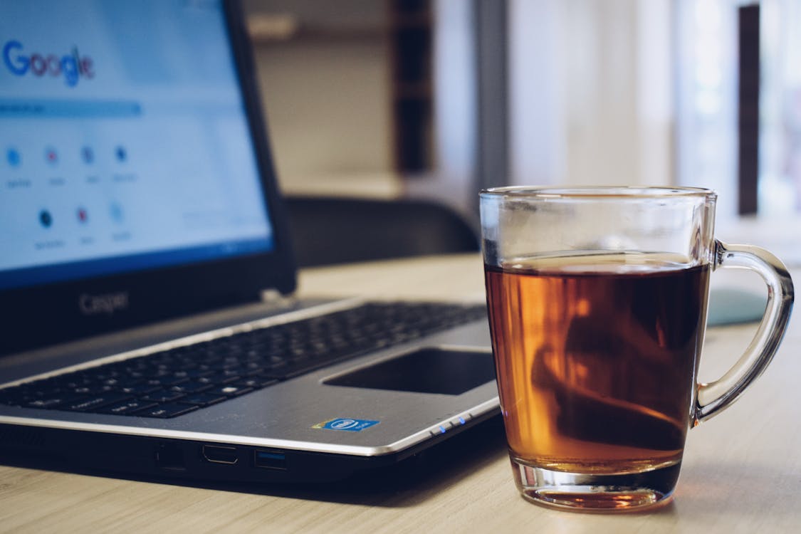 Free Clear Drinking Glass on Black Laptop Computer Stock Photo
