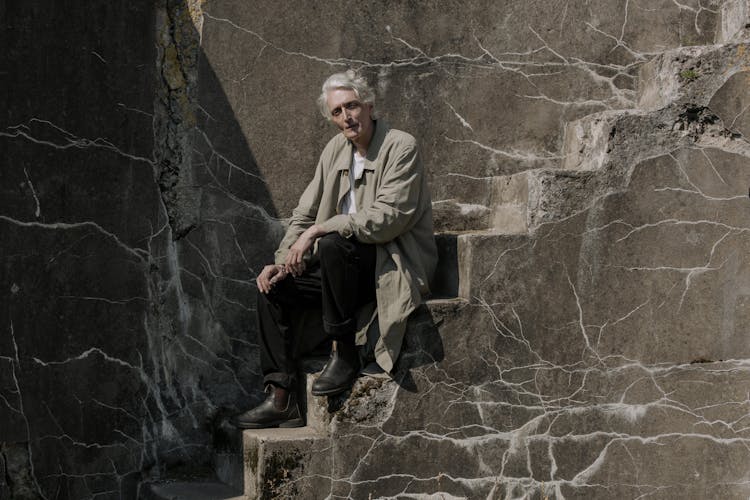 Elderly Man Sitting On The Stairs 