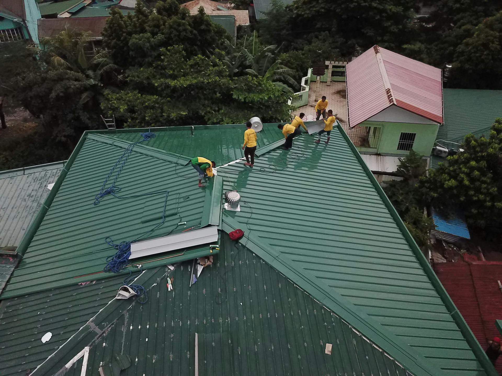 Workers installing green roof panels in Caloocan, Philippines.