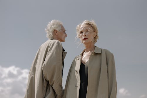 Two Elderly People in Brown Trench Coats