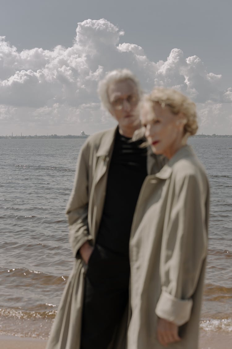 Two Elderly People In Brown Trench Coats