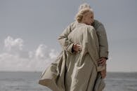 老年夫妇在海边深情拥抱，传递温暖和陪伴