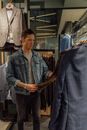 一名年轻男子正在一家时尚服装店里检查一件西装外套