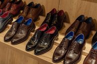 店内木制货架上，优雅的皮革礼服鞋正在展示