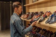 一名穿着牛仔夹克的男子在商店里挑选皮鞋