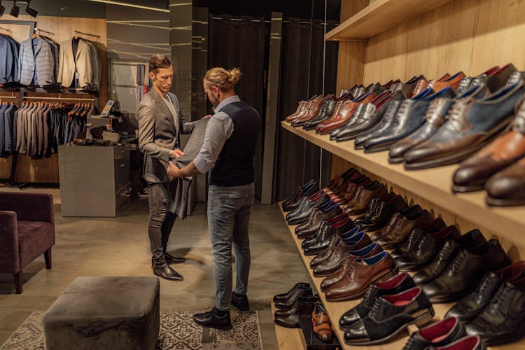 Men Looking At A Pair Of Pants In A Fashion Boutique