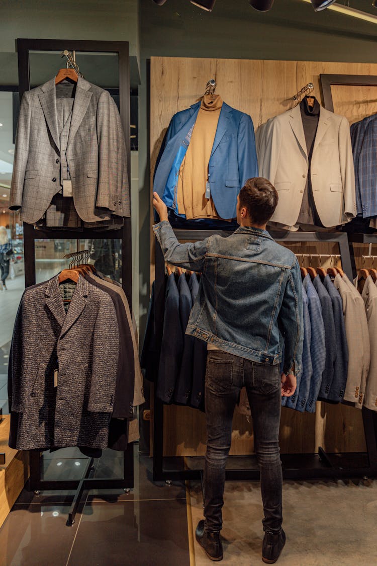 A Man Looking At A Suit In Display At A Store