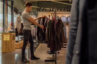 一名男子在一家现代服装店里专注地浏览时尚西装外套