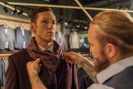 一位顾客在一家现代化的服装店里得到了一条围巾的帮助