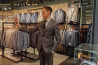 一名穿着西装的男子在高档时尚精品店里购物并自拍