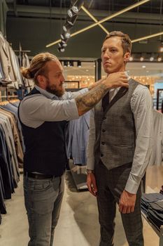 裁缝在现代服装店里为顾客调整背心