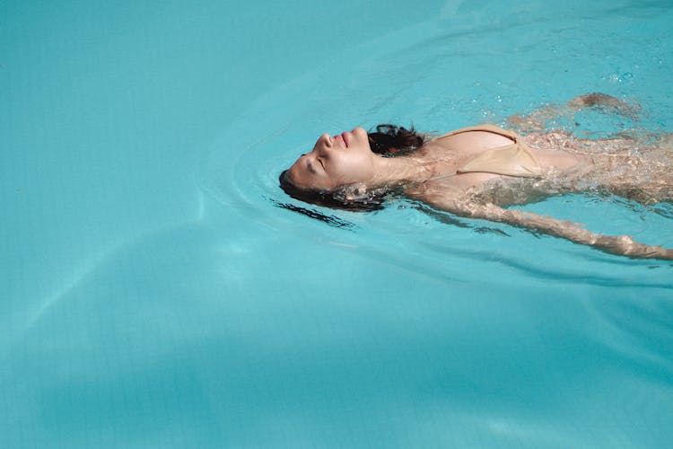 Relaxed Woman Swimming Back Crawl In Pool