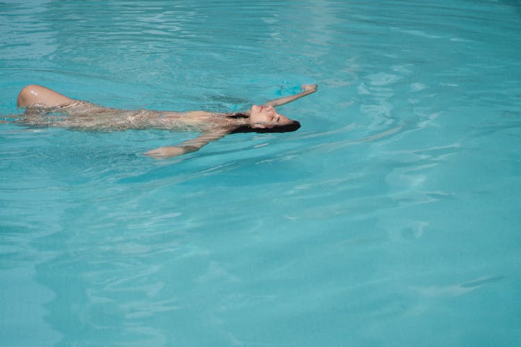 Positive Woman Swimming On Back In Pool