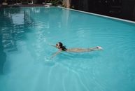 Pretty woman swimming in pool in resort