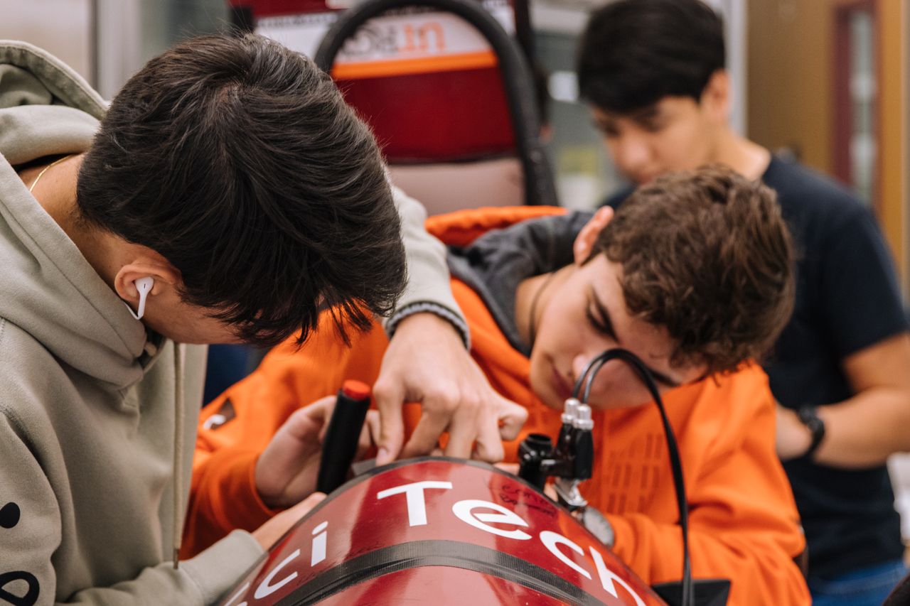 teenagers engaged in a hands on engineering project at a workshop focu