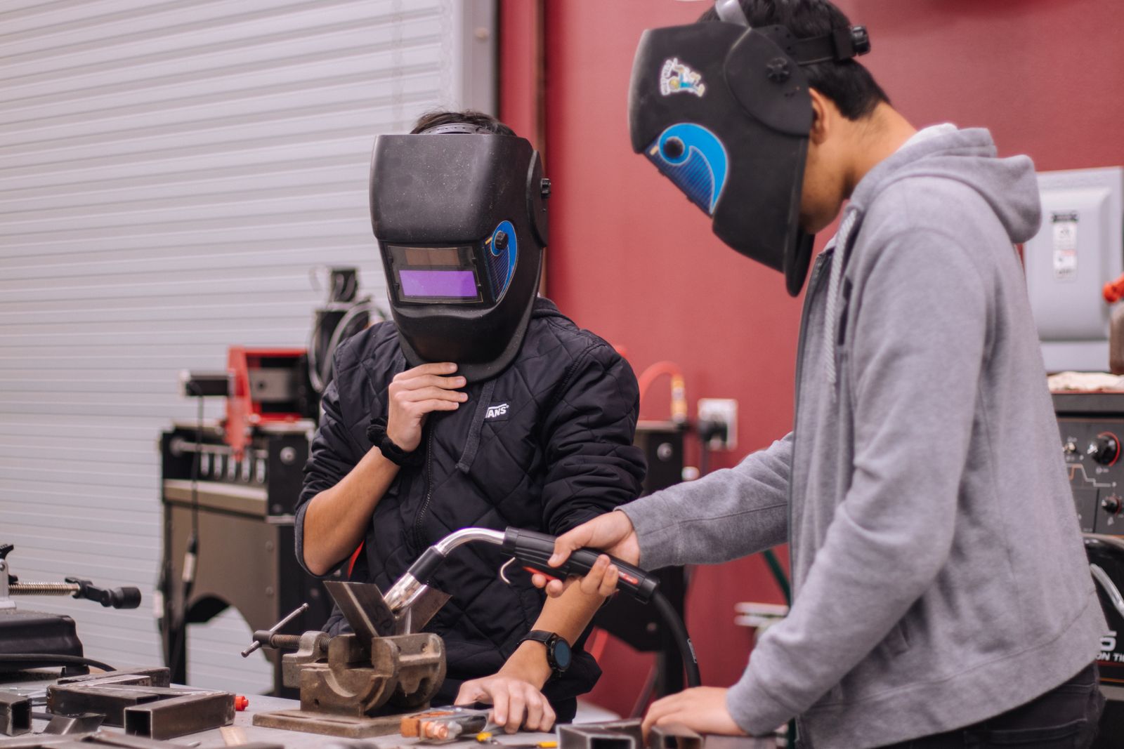 Trainees learning to weld in a workshop