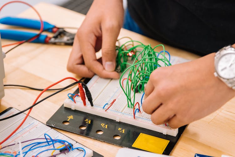 Hands Of A Person Holding Wires On A Breadboard