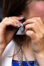 Young female putting stylish earring