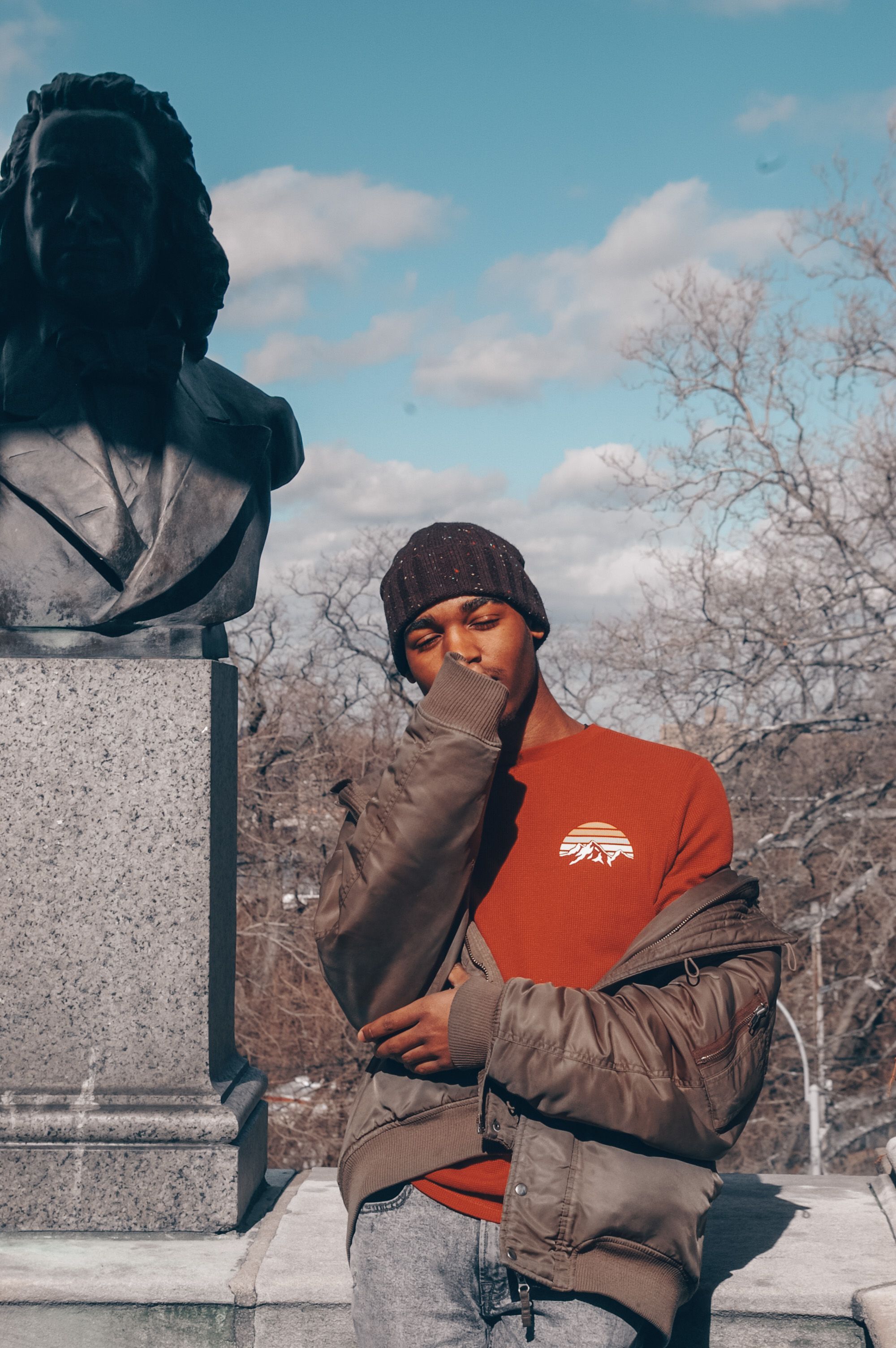 Man in Brown Jacket Standing Beside a Sculpture · Free Stock Photo