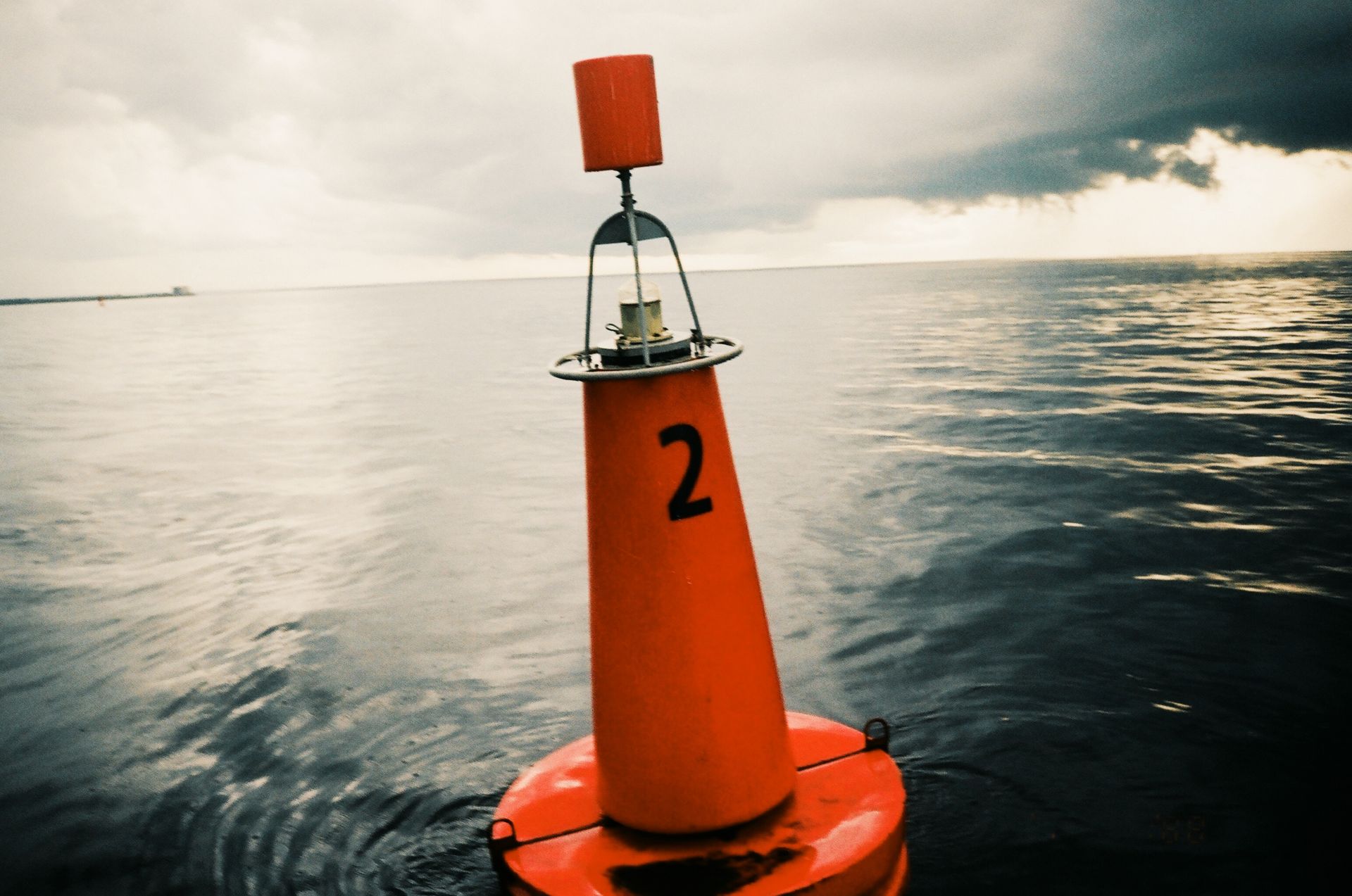 A monitoring buoy bobbing in the open sea under an overcast sky.