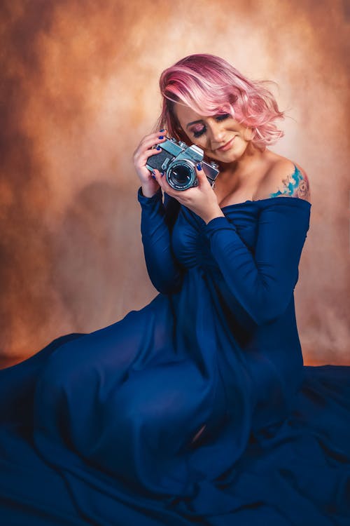 Woman in Blue Dress Holding Camera