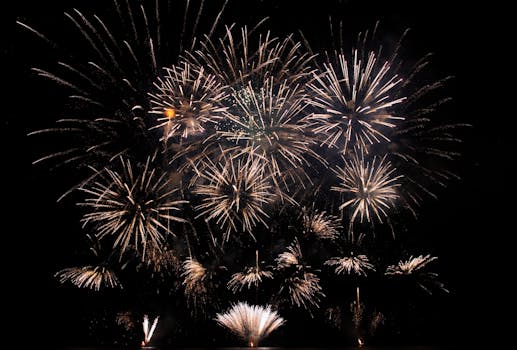 Abstract of vibrant glowing fireworks exploding high in black sky late at night