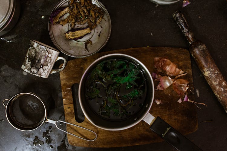 Saucepan With Broccoli In Water Near Fried Eggplants In Kitchen