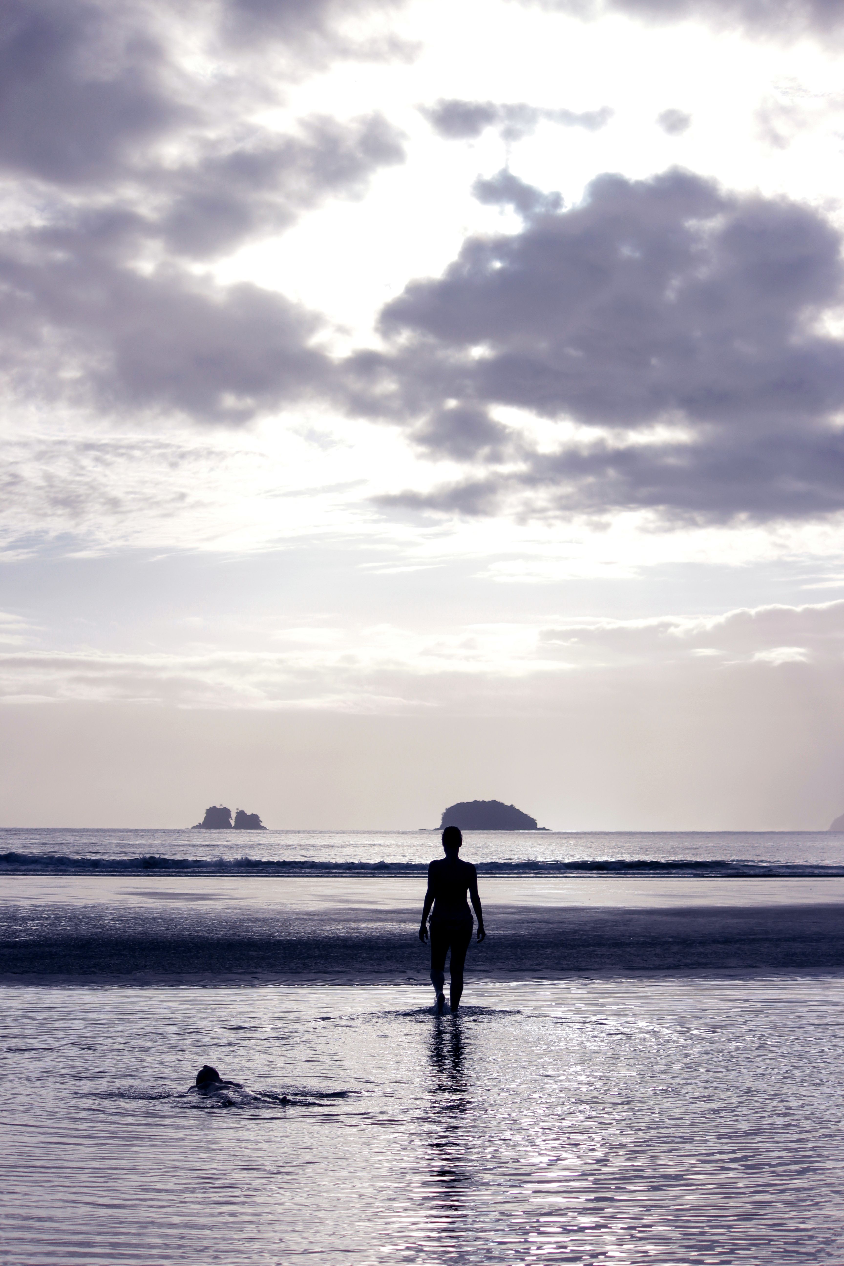A serene beach scene with a silhouetted figure against a vibrant sunset, enhancing the peaceful atmosphere.