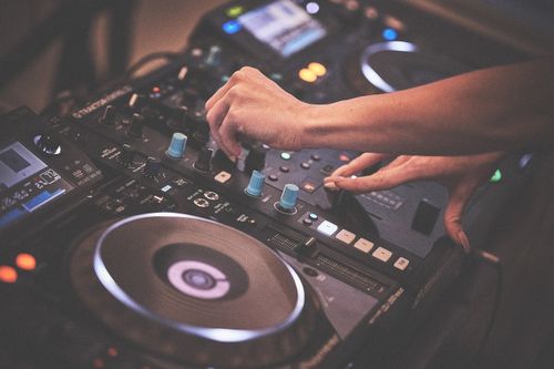 Free Close-up of a DJ mixing music using professional audio equipment indoors. Stock Photo