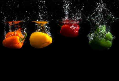 Free Vibrant bell peppers submerged in water showcase fresh produce in motion. Stock Photo