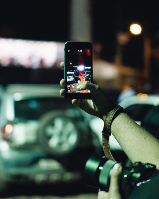 Capturing the city nightlife using a smartphone camera with a focus on vehicles.