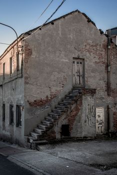 西班牙一座废弃建筑饱经风霜，外墙开裂，外部楼梯残破