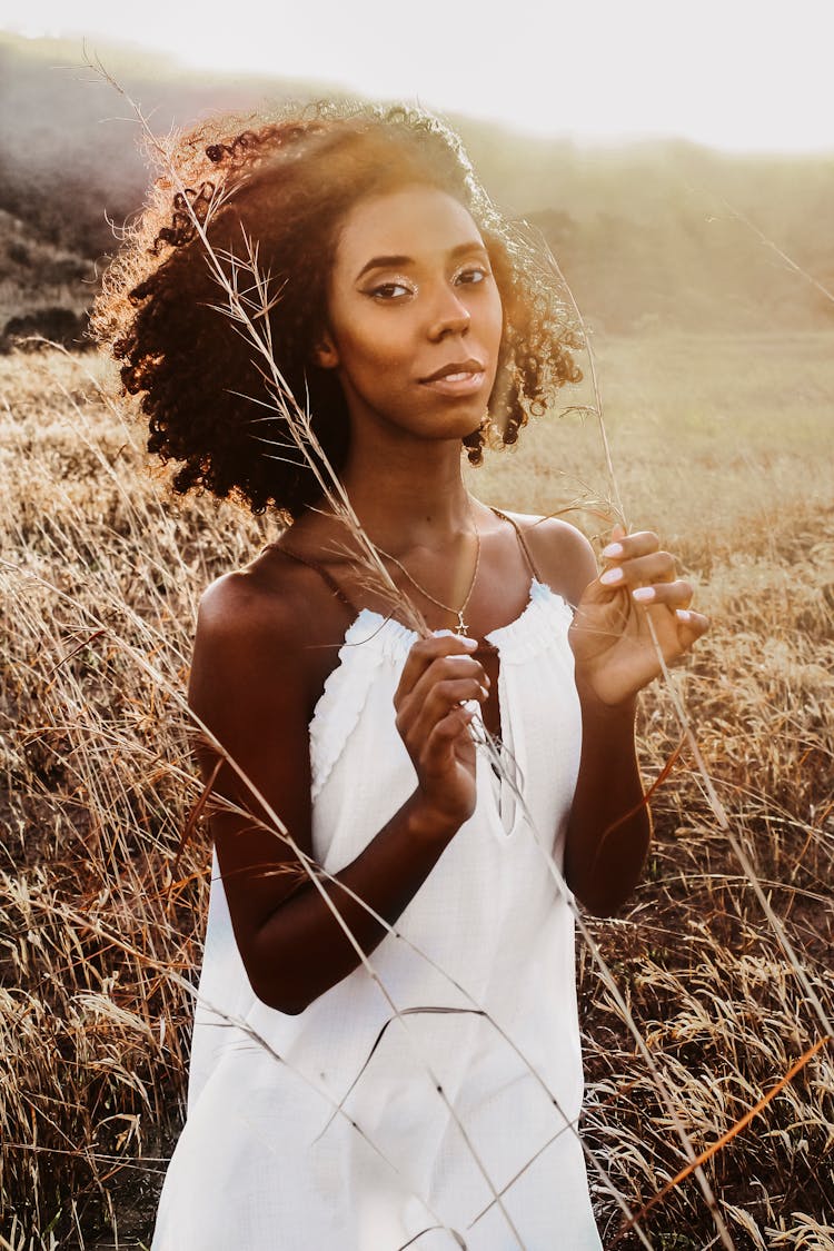 Black Woman In Grassy Meadow In Evening Time