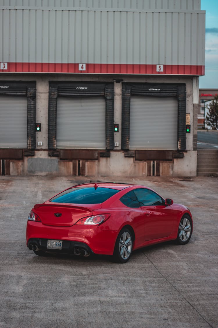 A Red Sedan Car Parked On The Road