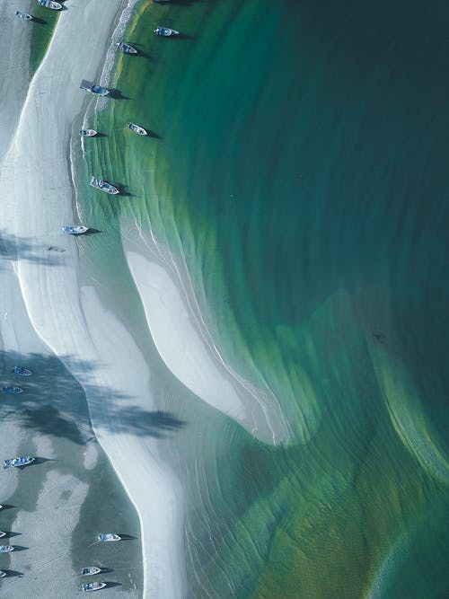 Masmavi Denizin Yakınında Beyaz Kumlu Sahile Yerleştirilen Tekneler