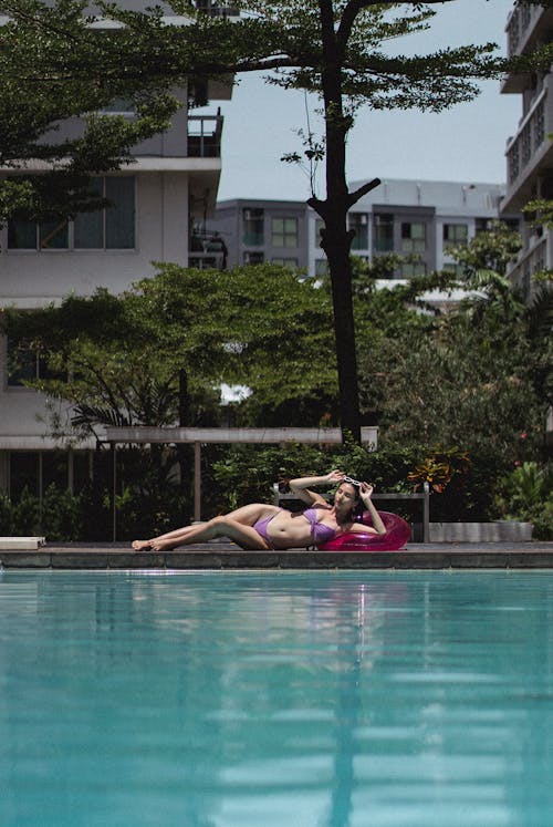 Graceful woman lying on poolside in sunny poolside