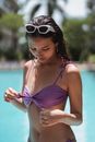 Attractive woman chilling in pool and touching swimsuit bra ties