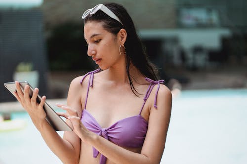 Giovane Donna In Costume Da Bagno Utilizzando Tablet A Bordo Piscina
