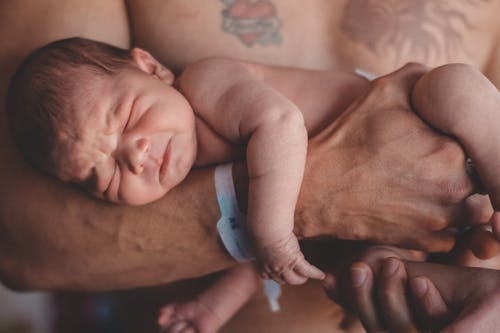 Free Man Carrying a Baby Stock Photo