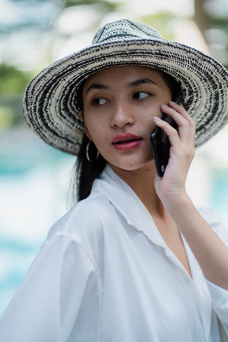 Stylish Young Ethnic Woman Having Phone Call At Poolside